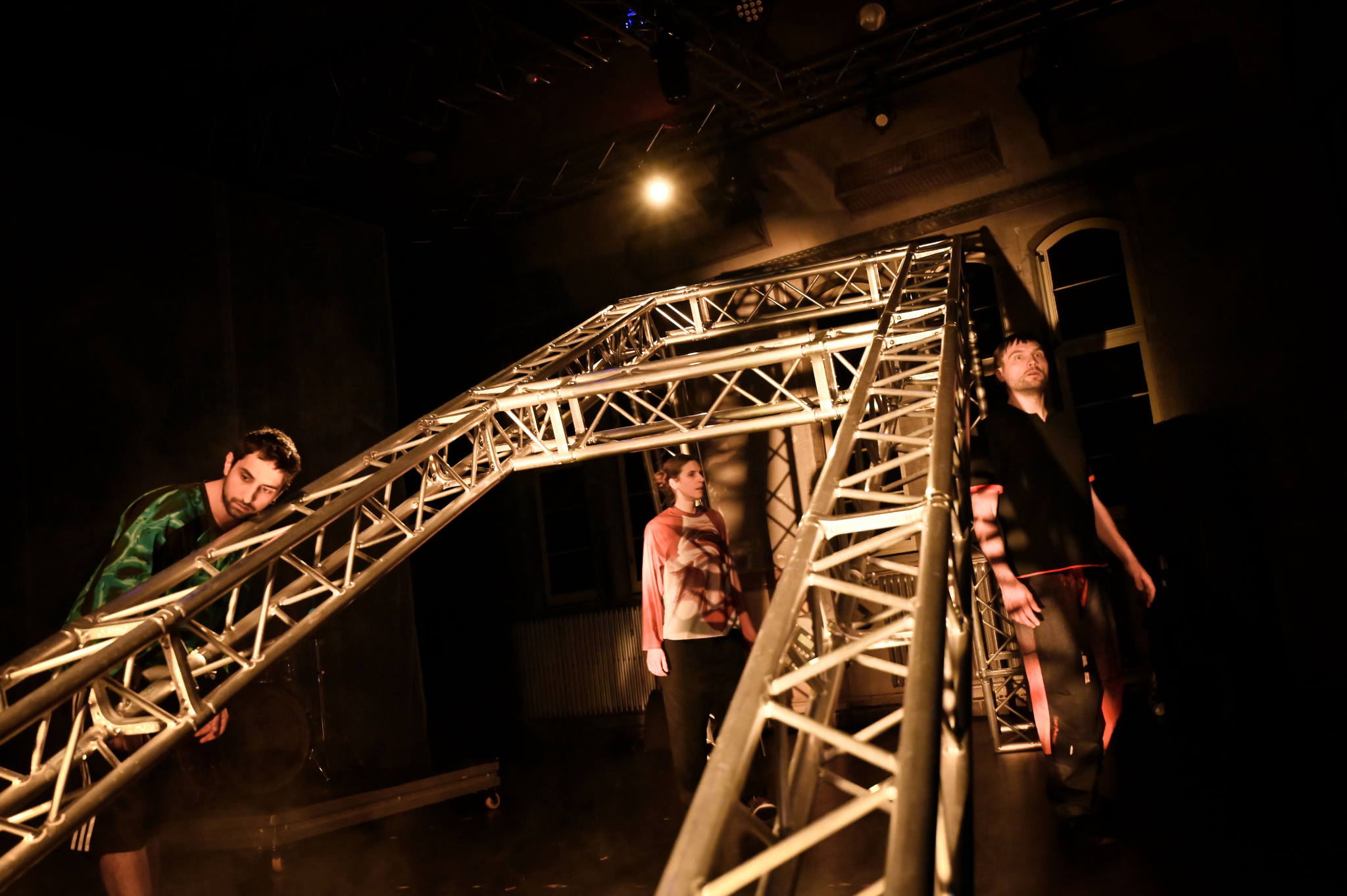 Drei Personen stehen um ein schräges Projekt herum.